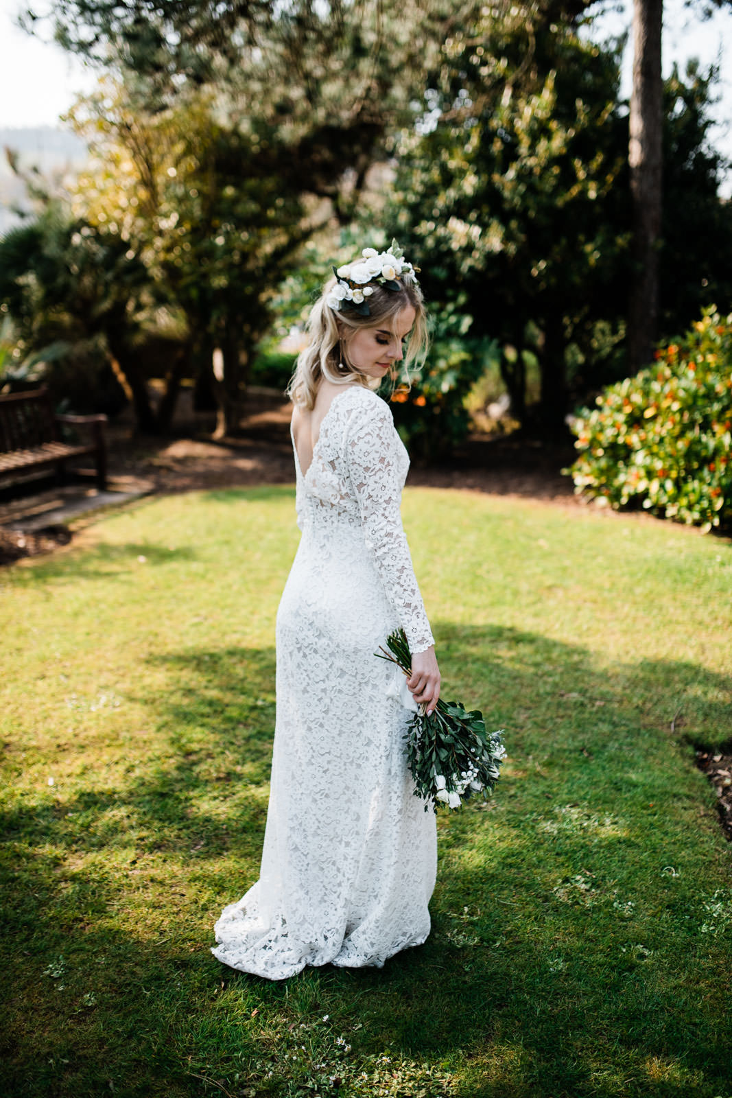 bride holding white flowers stood an green lawn