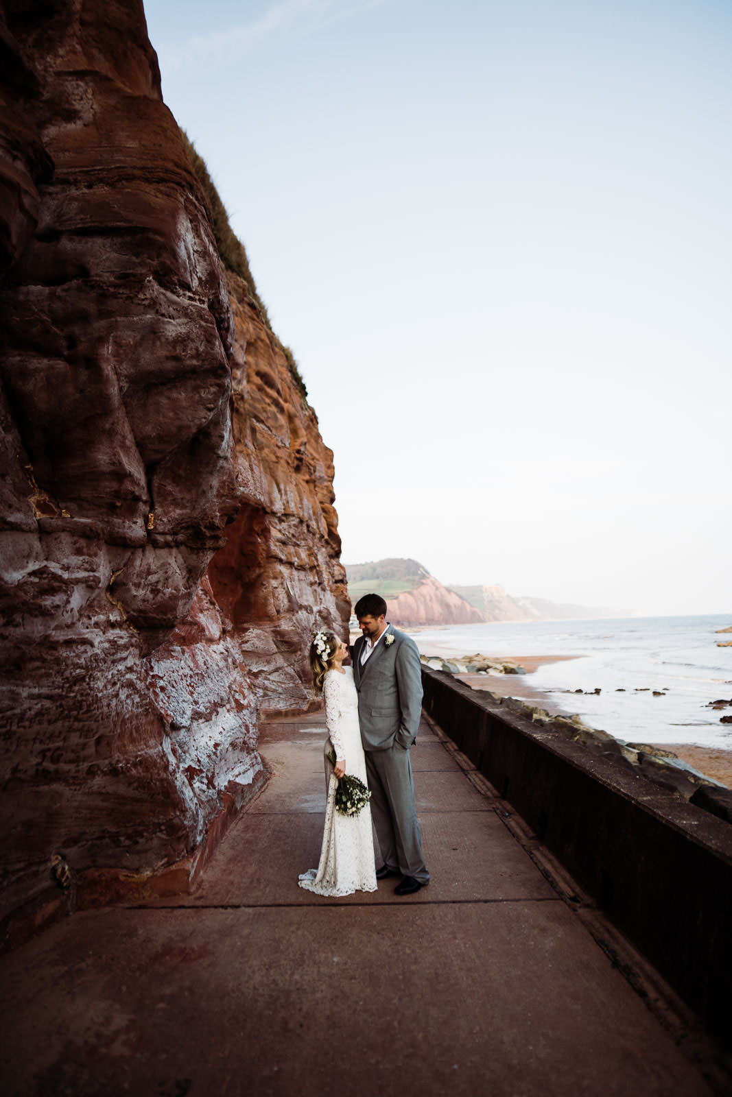 bride and groom stood near red cliffs
