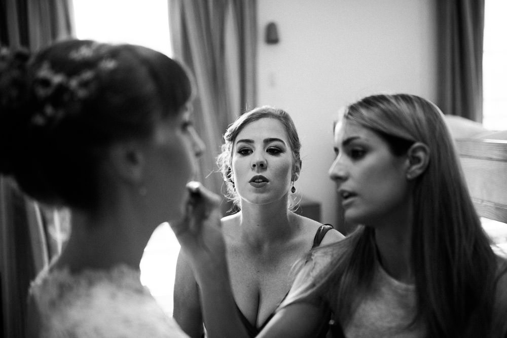 bride with flowers in her hair having make up applied