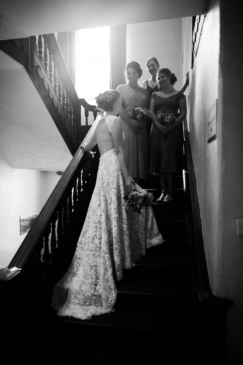 bride and bridesmaids stood on wooden stairs