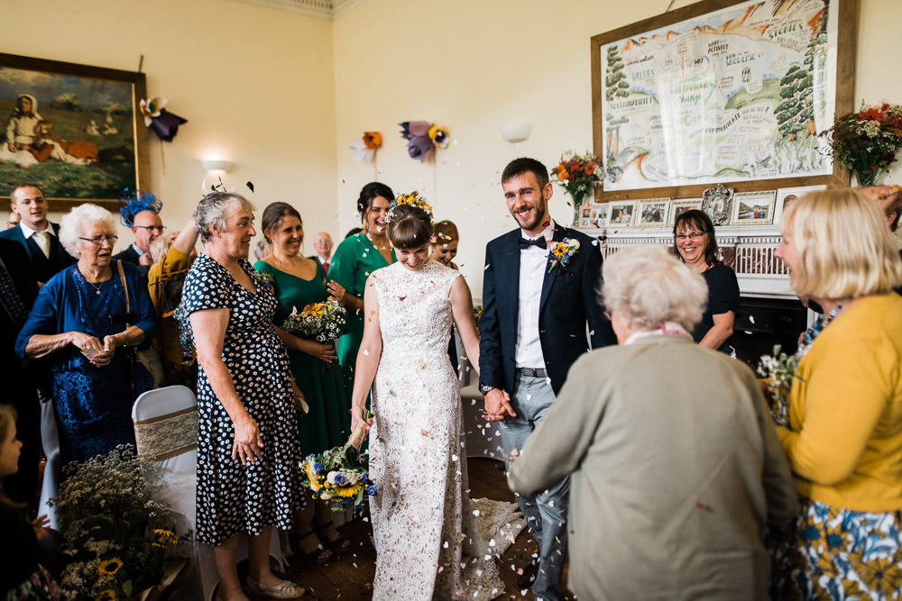 confetti thrown inside large manor house at wedding