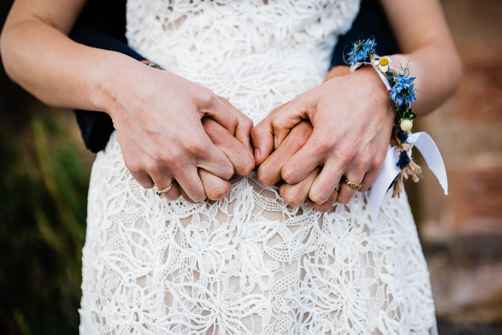 bride and groom holding hands with wedding rings