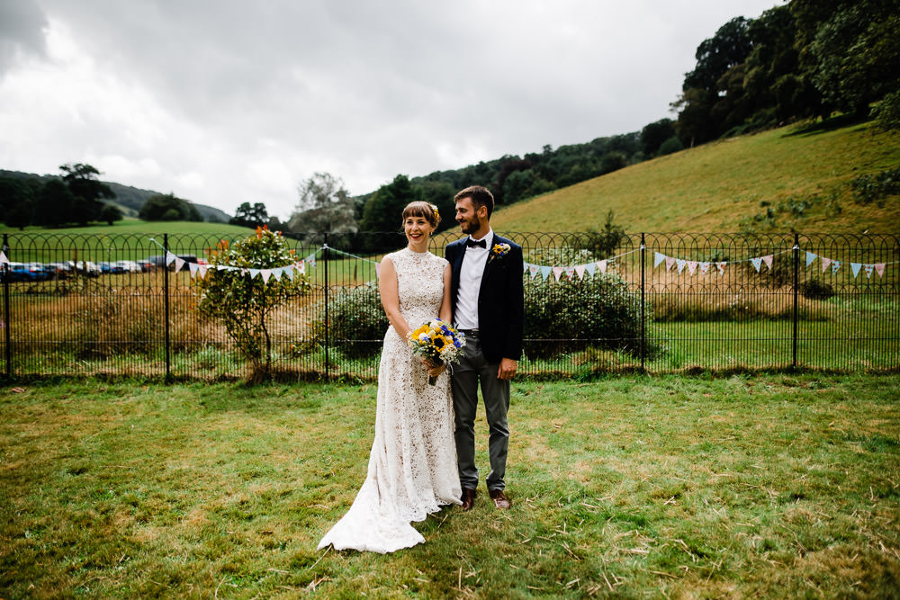 bride and groom stood on green grass