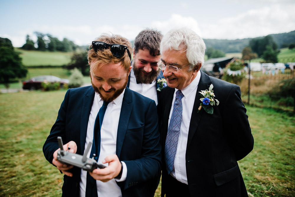 men flying a drone at a wedding