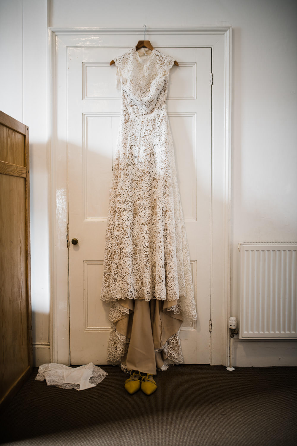 vintage wedding dress hanging on a door frame