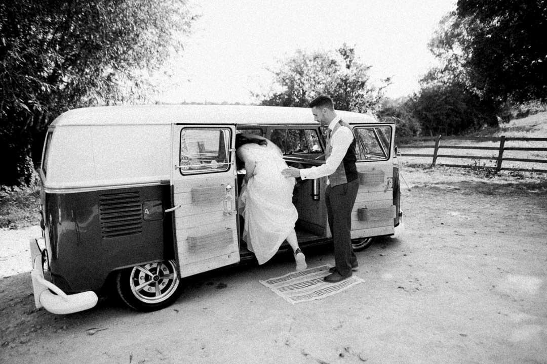 bride getting into camper van during daytime