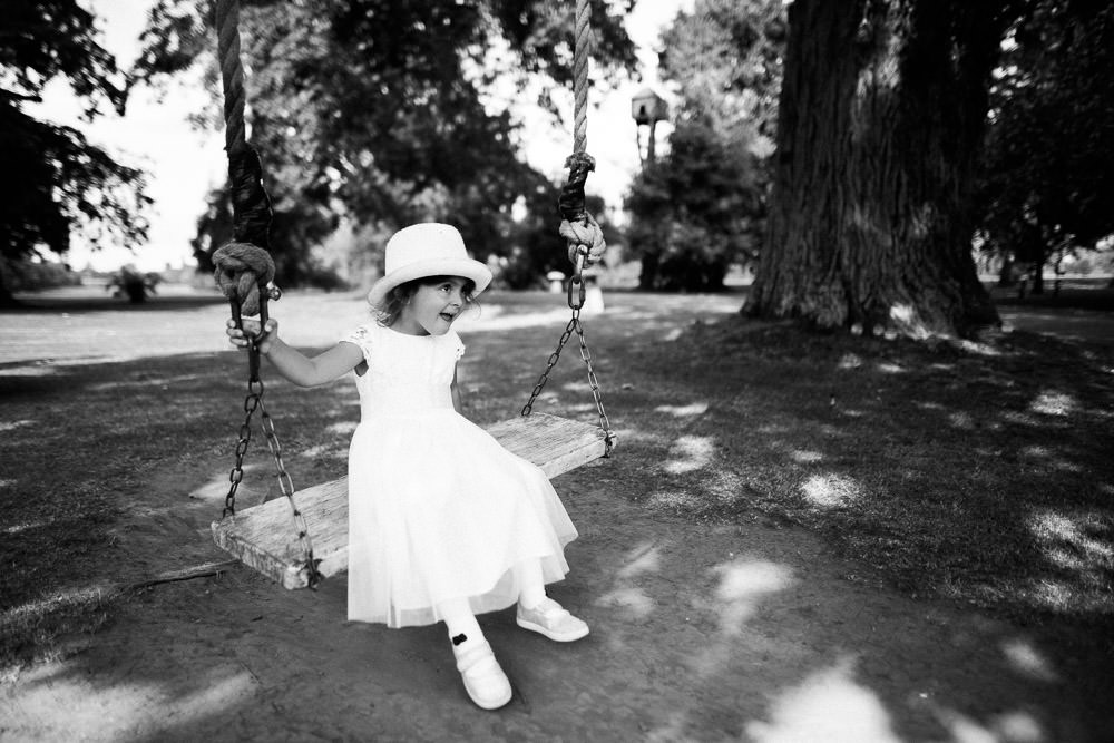 little girl in white dress on a wooden swing