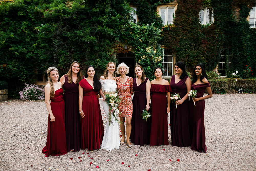 Bride and her bridesmaids stood outside of house