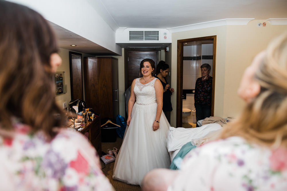bride smiling in hotel waring a wedding dress