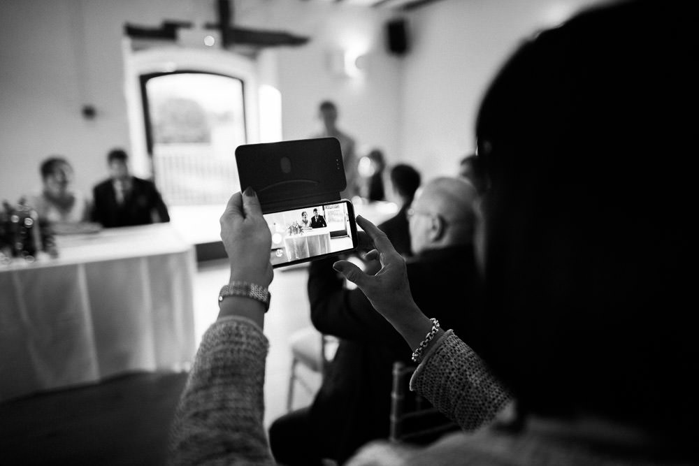 wedding guest taking a photo on phone at wedding