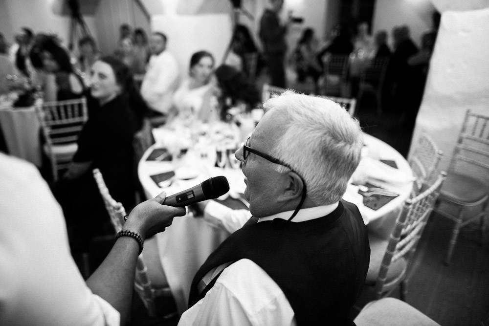 man singing into microphone at wedding