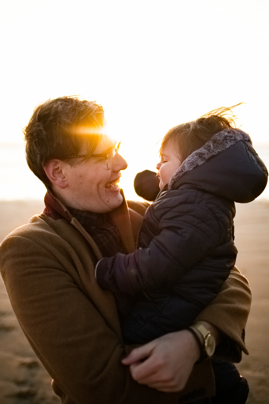 man holding young boy in sunset