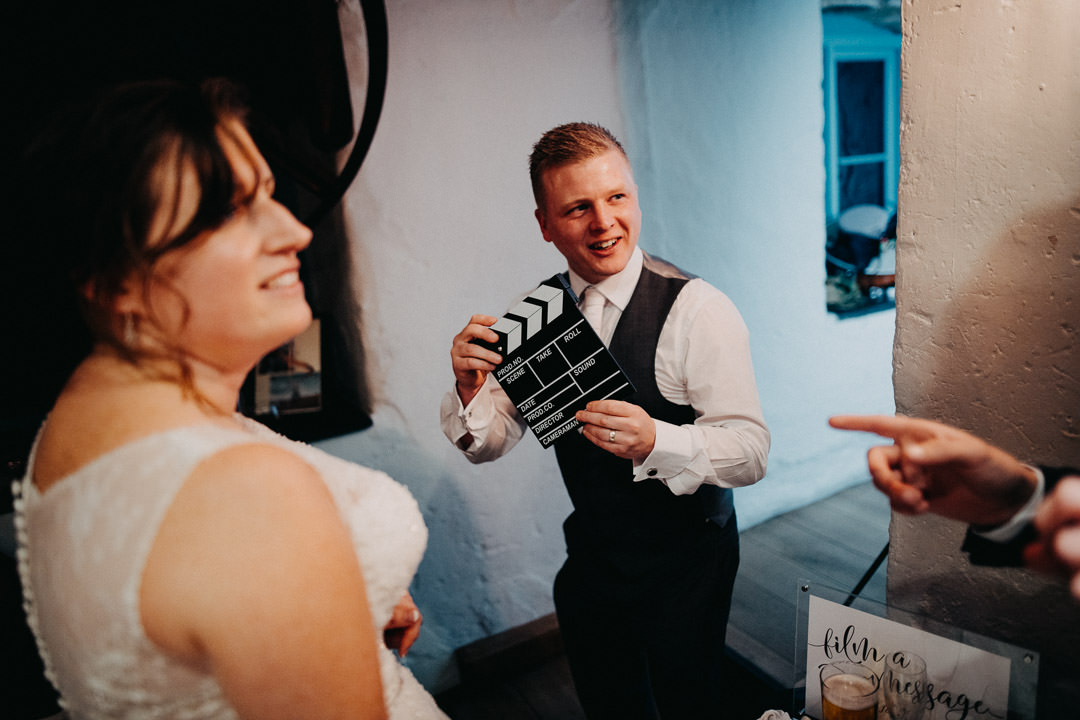 man holding movie clap board at wedding