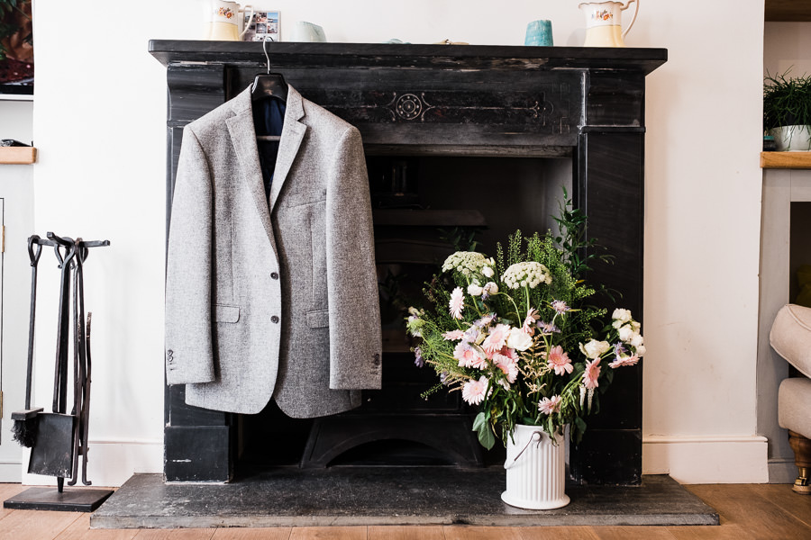 flowers and jackets hanging on fire place