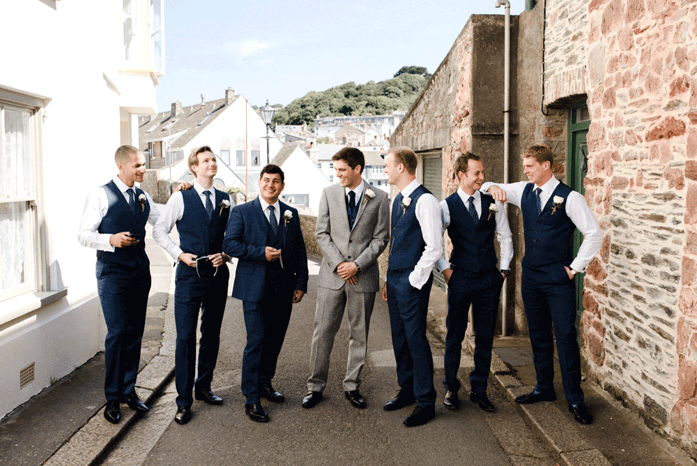 groomsmen standing in English street smiling during day time