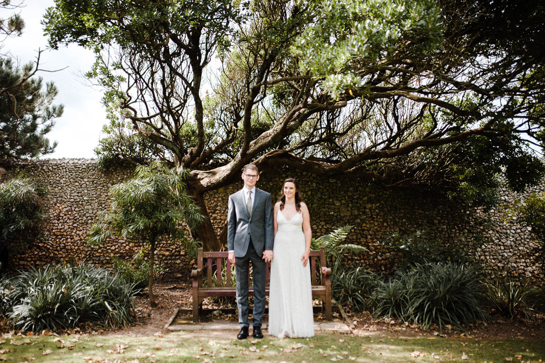 bride and groom stood under large tree