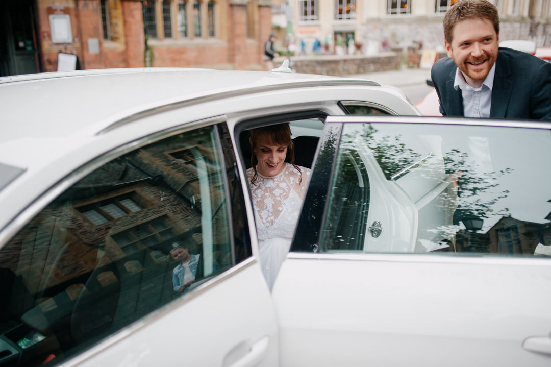 bride getting out of white sports car in street