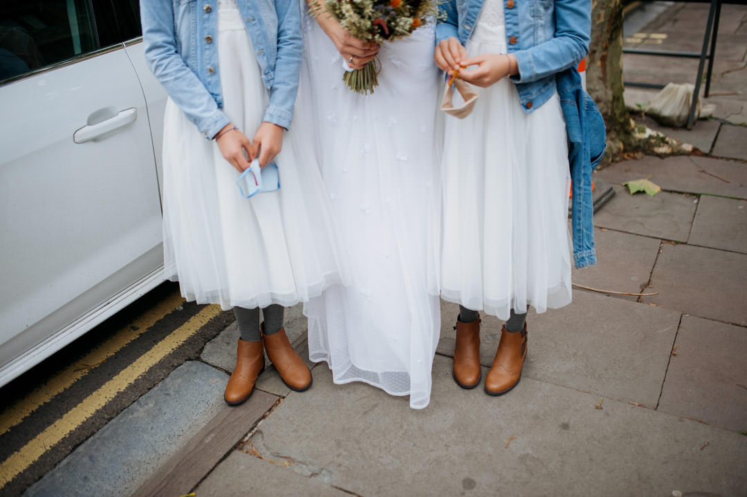 bride and bridesmaids stood in cobbled street