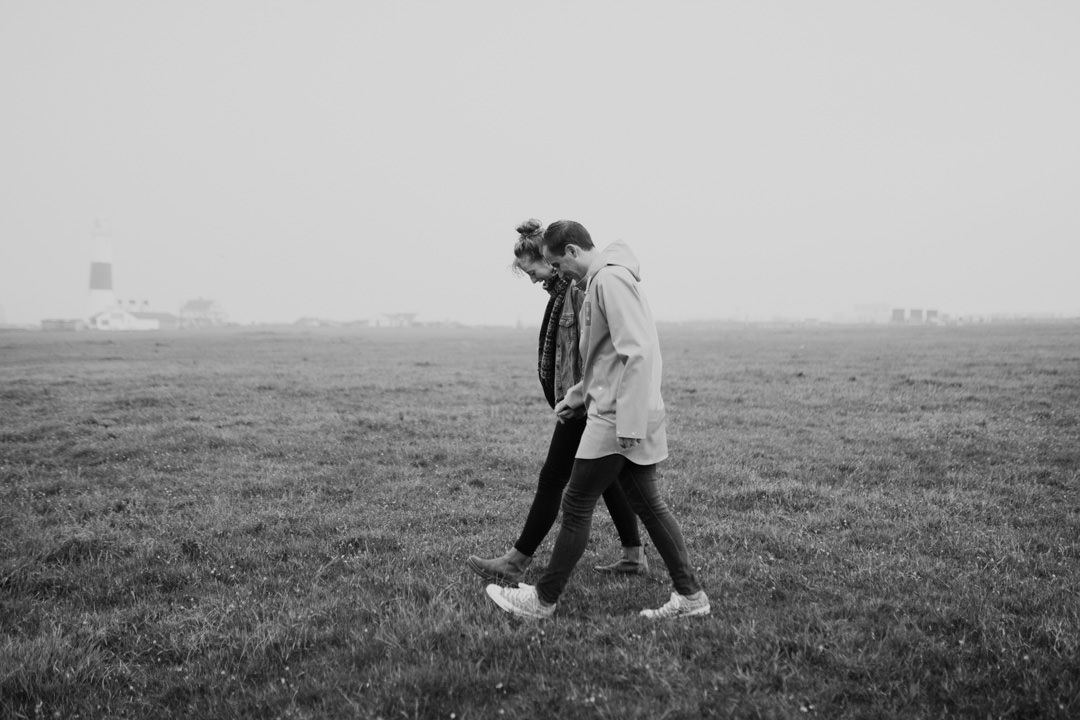 man and woman walking in rain smiling