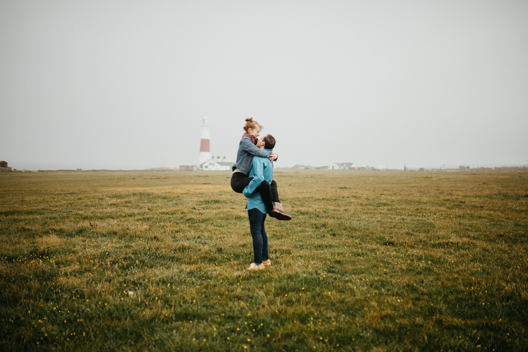 man lifting girl up in the air in field