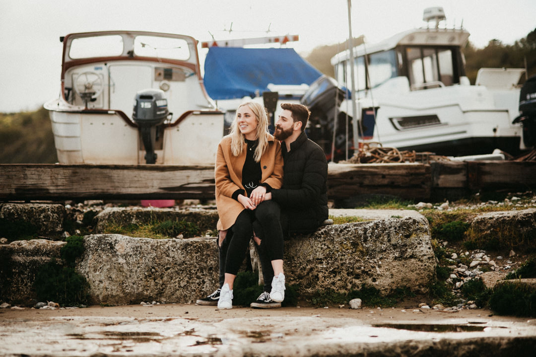 young couple sat in harbour near sea
