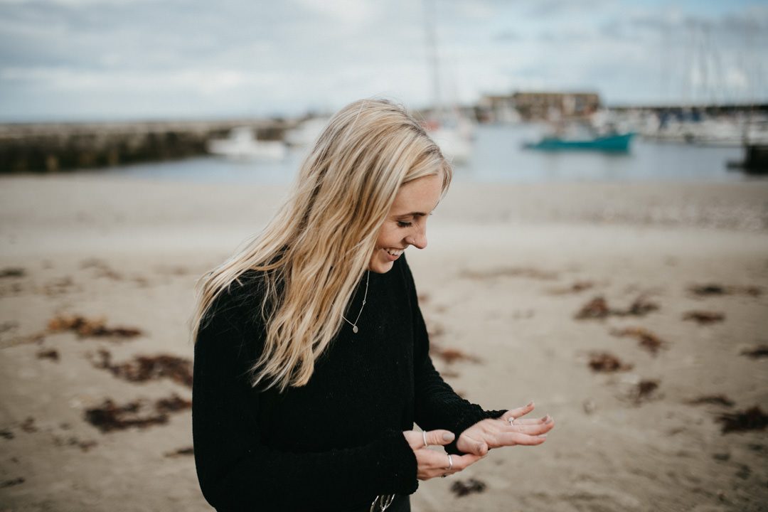 woman with blonde hair looking at engagement ring