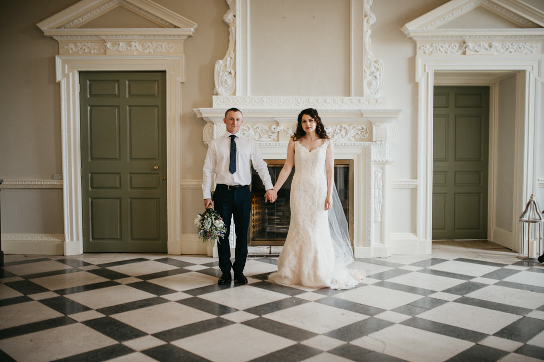bride and groom holding hands in marble hall