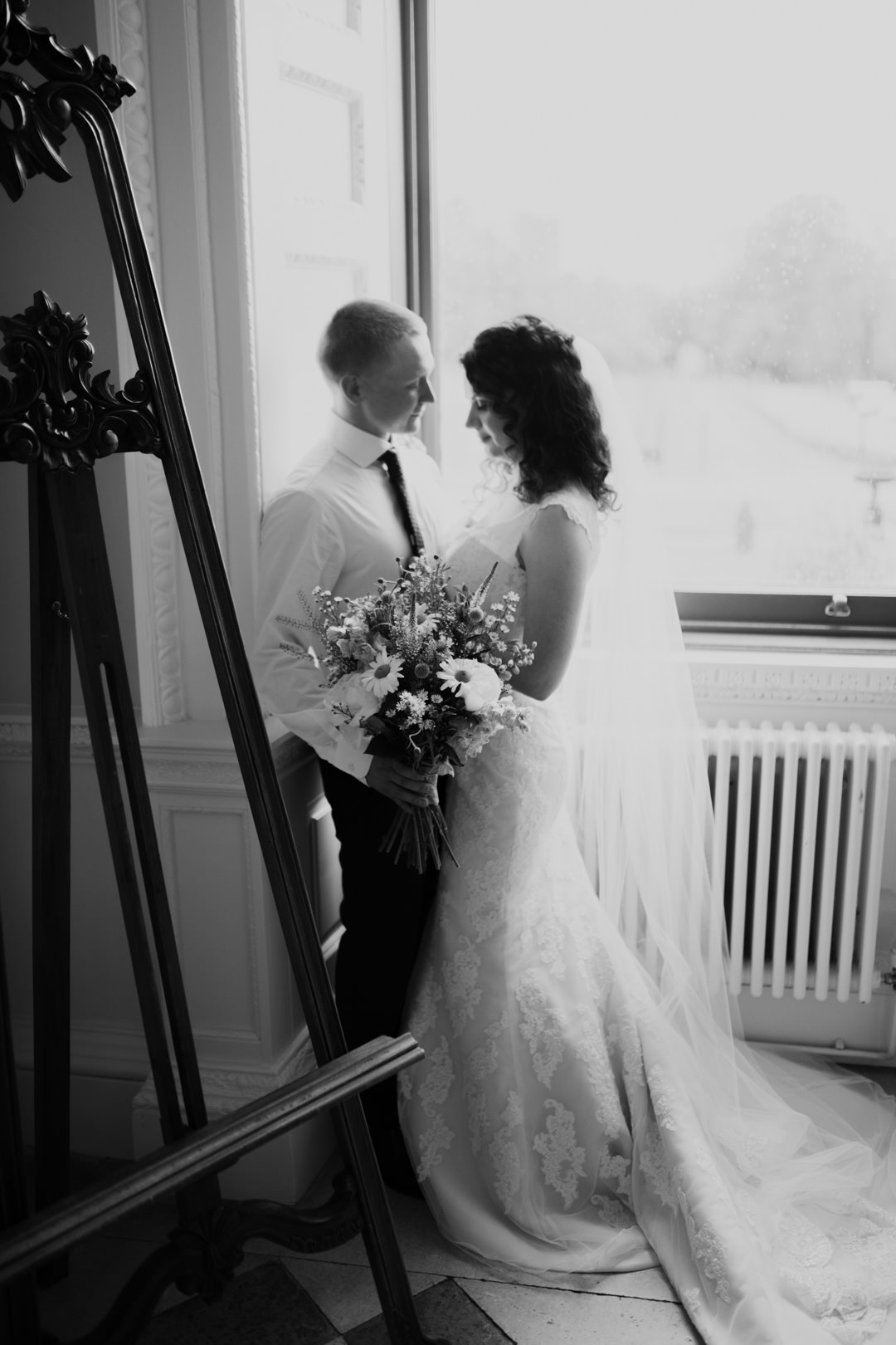 bride and groom stood near large window