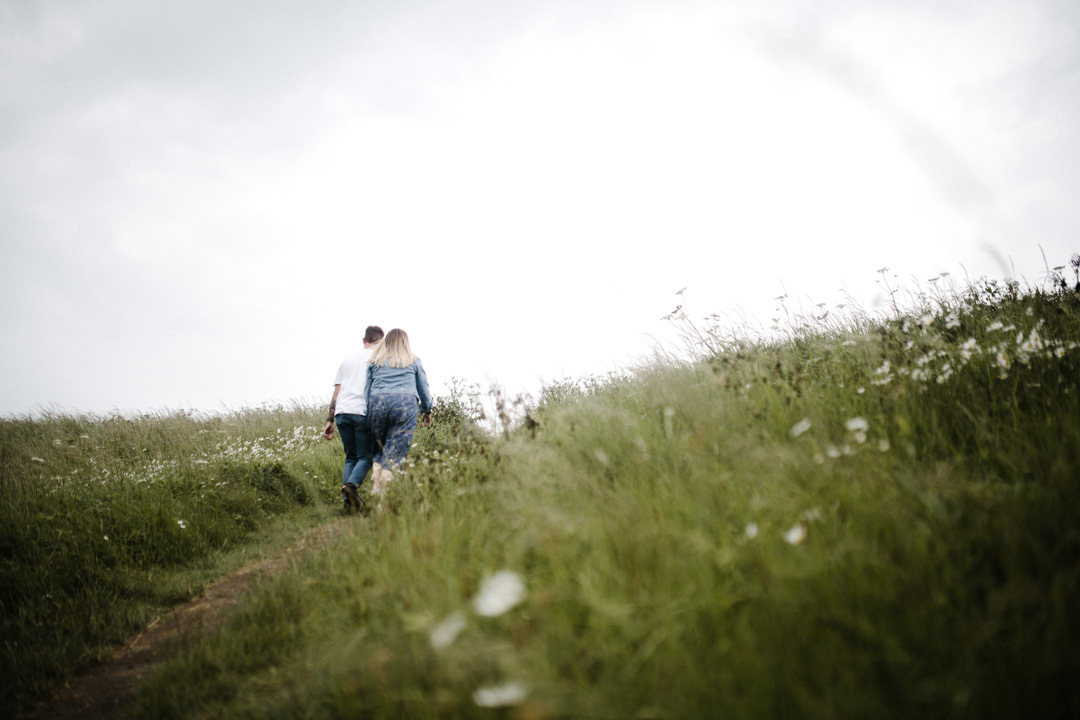 man and woman walking in long grass