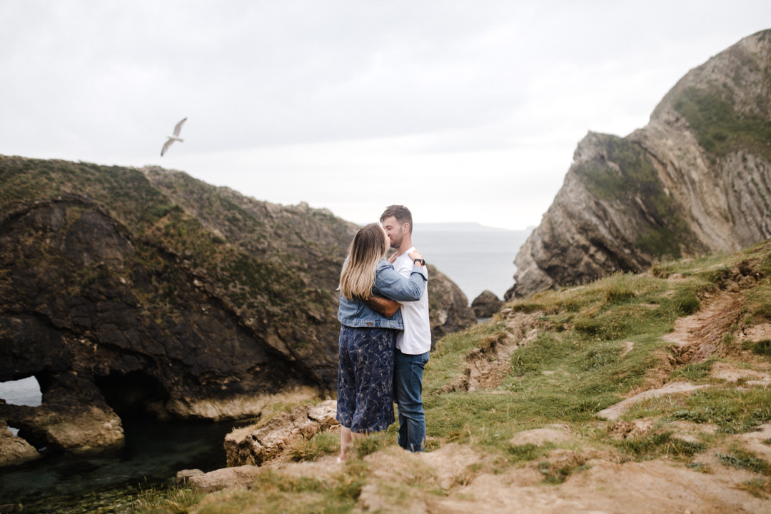 young couple stood near cliff edge