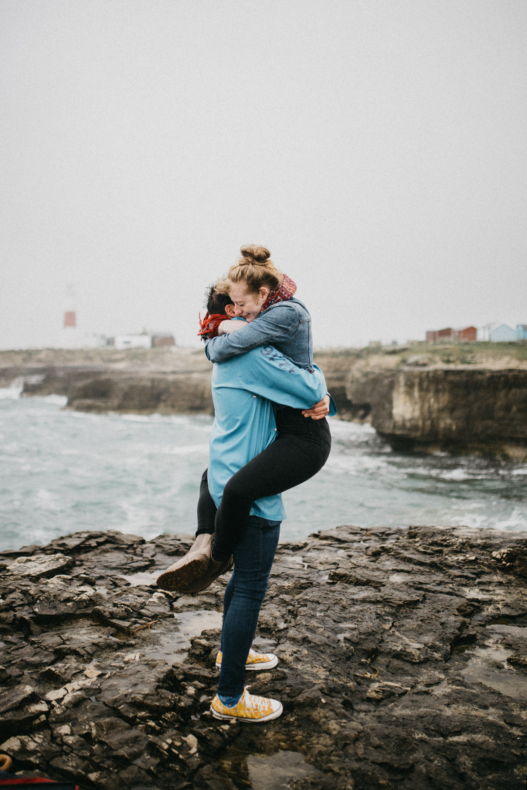 man and woman kissing next to stormy ocean