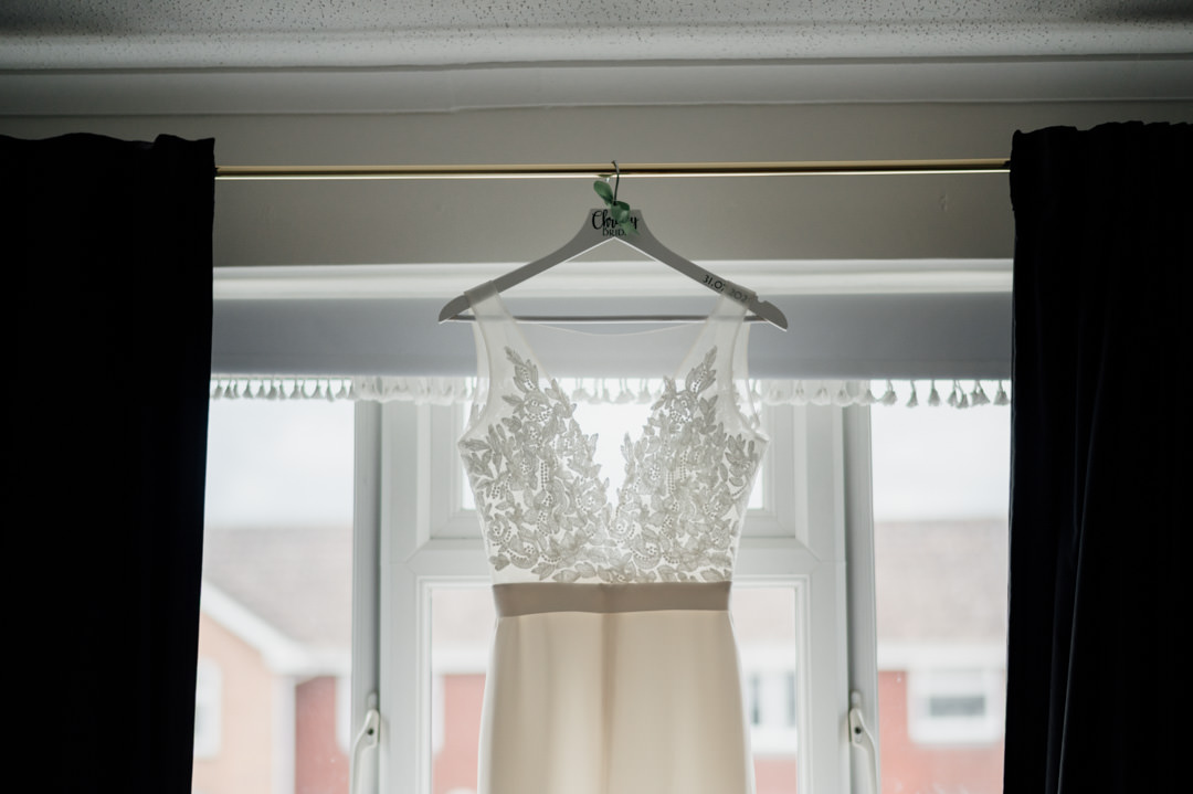 wedding dress hanging in window of house