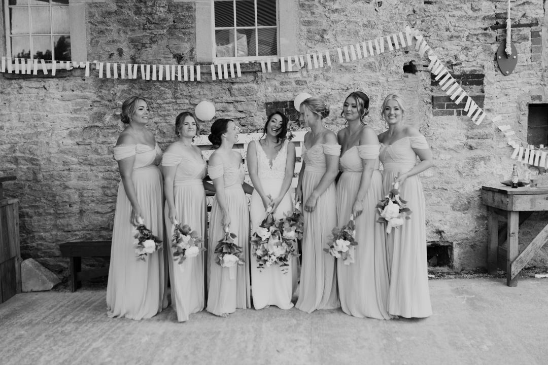 bridal party stood in a line smiling and laughing