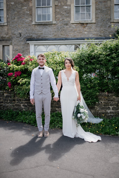 bride and groom stood outside country house