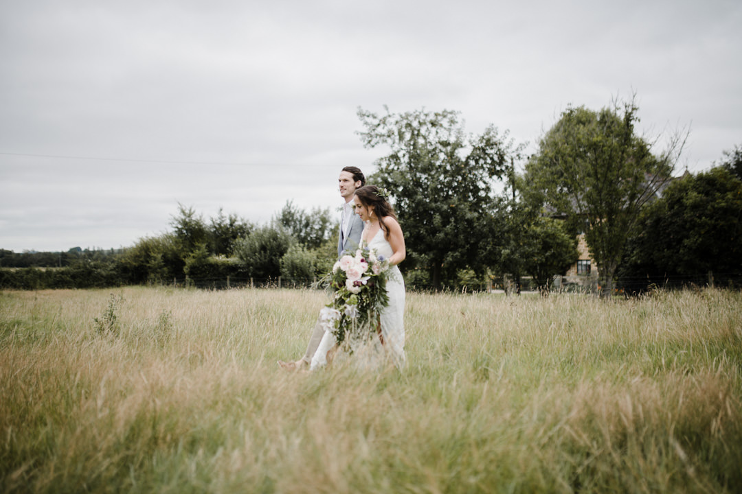 bride and groom in long grass meadow
