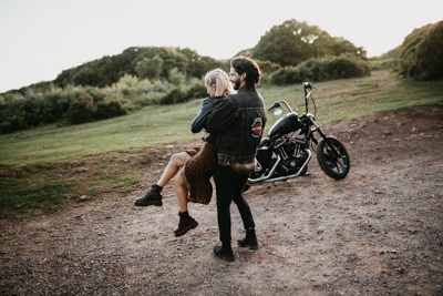 young biker couple dancing near motorbike