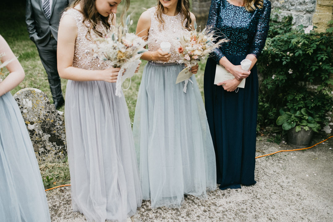 wedding bridesmaids holding flowers outside church