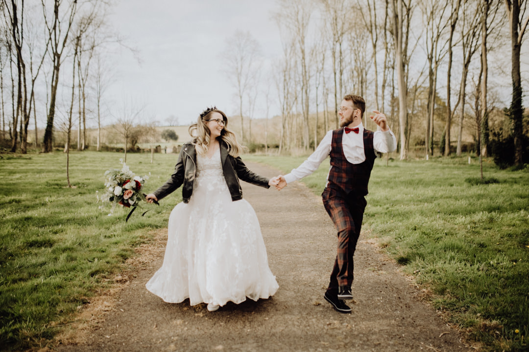 bride and groom skipping in woods
