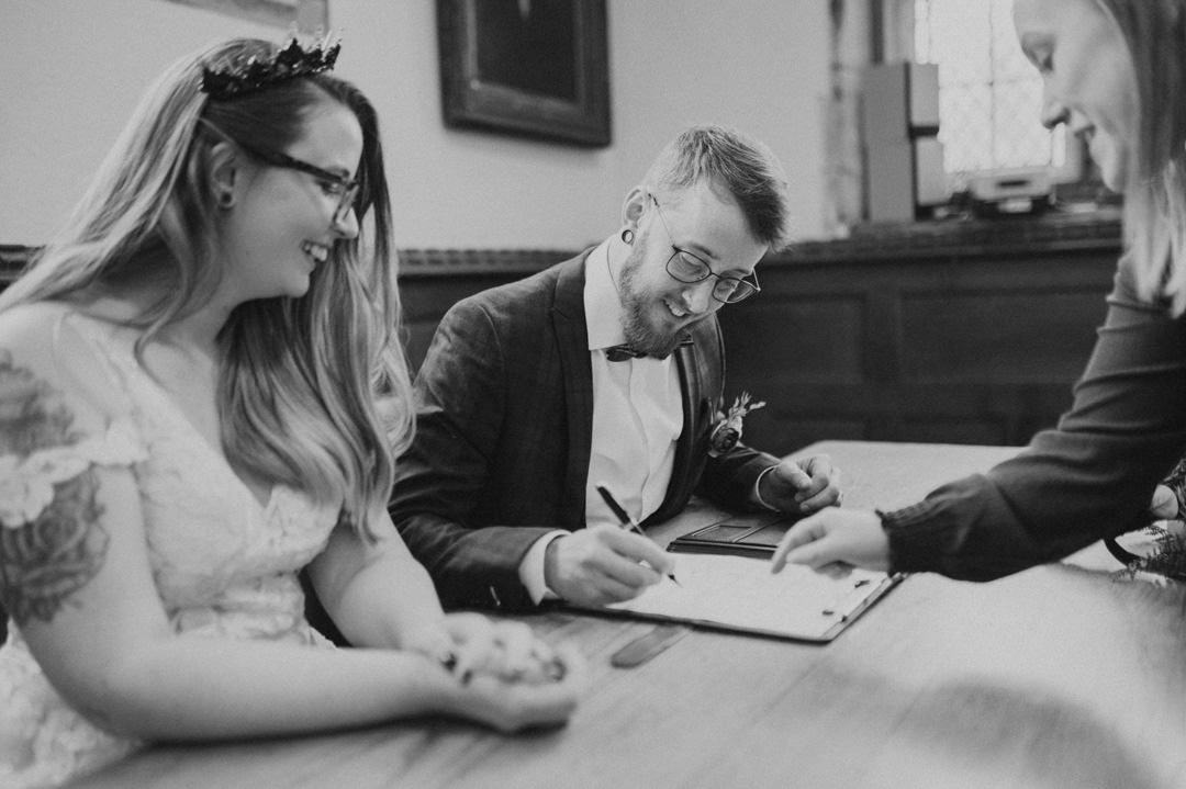 man in suit at wedding signing large open book