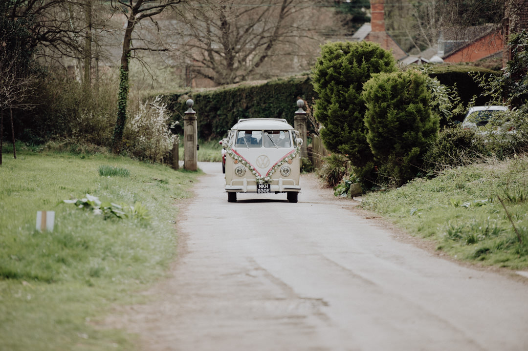 classic wedding camper van driving up narrow road