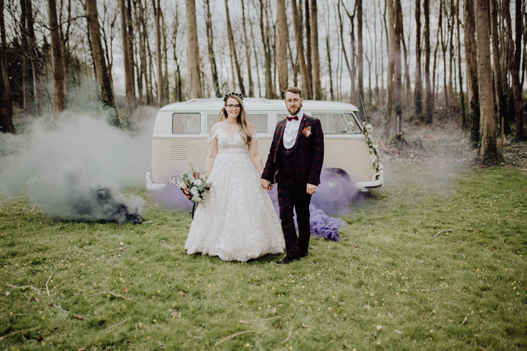 wedding couple stood next to camper van with smoke bombs
