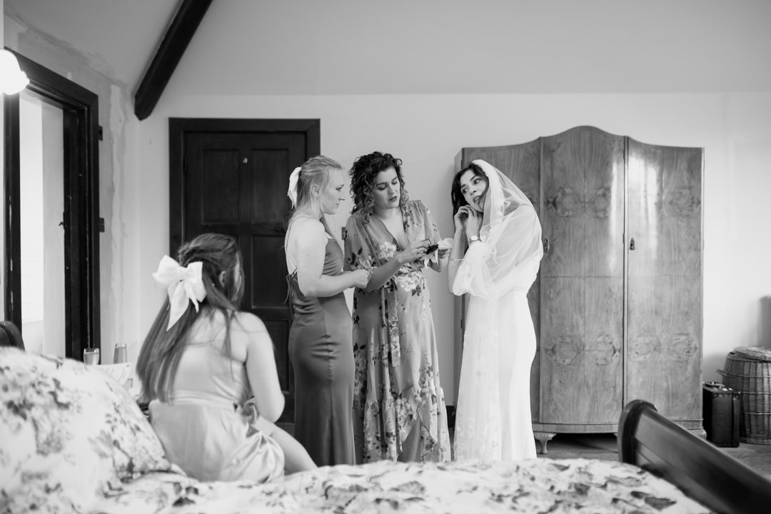bridesmaids getting dressed in large bedroom