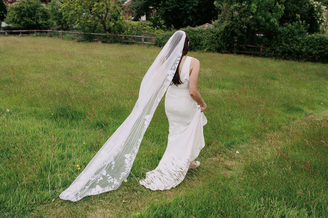 bride walking through meadow