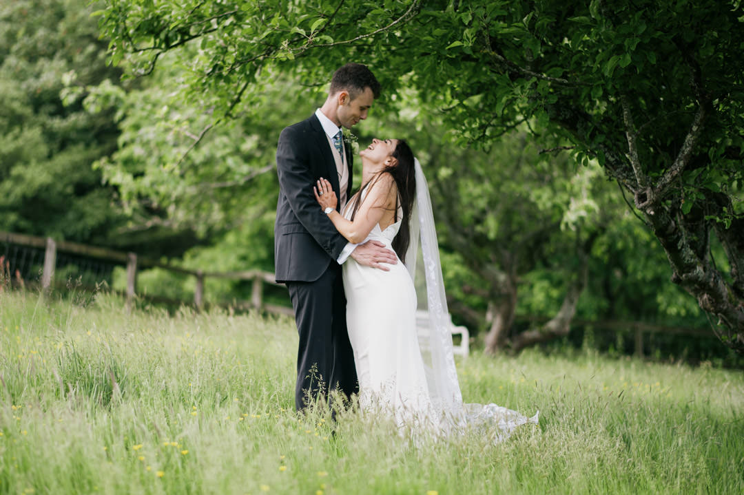bride and groom in meadow with yellow flowers