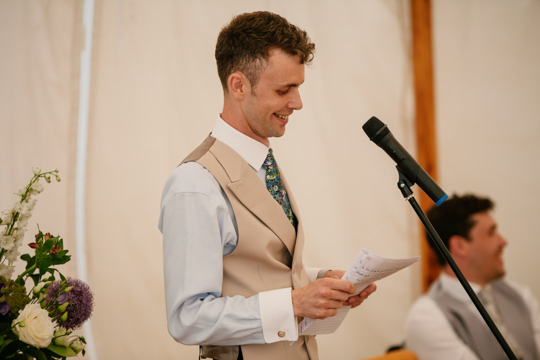 groom making speech holding microphone