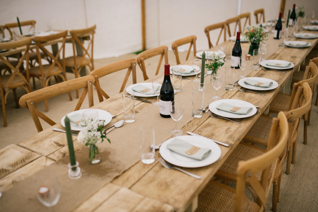 long wooden wedding table with cutlery and plates