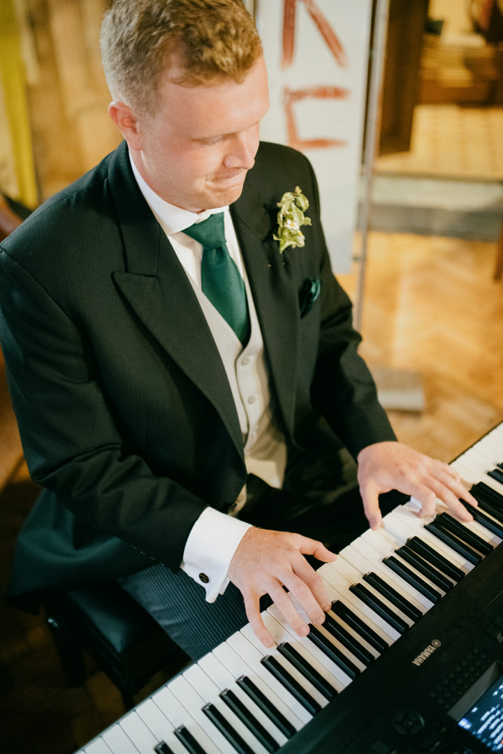 man playing piano at wedding