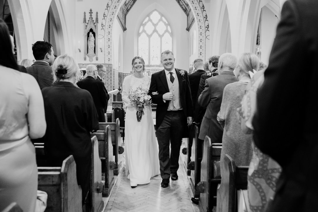 bride and groom walking out of church