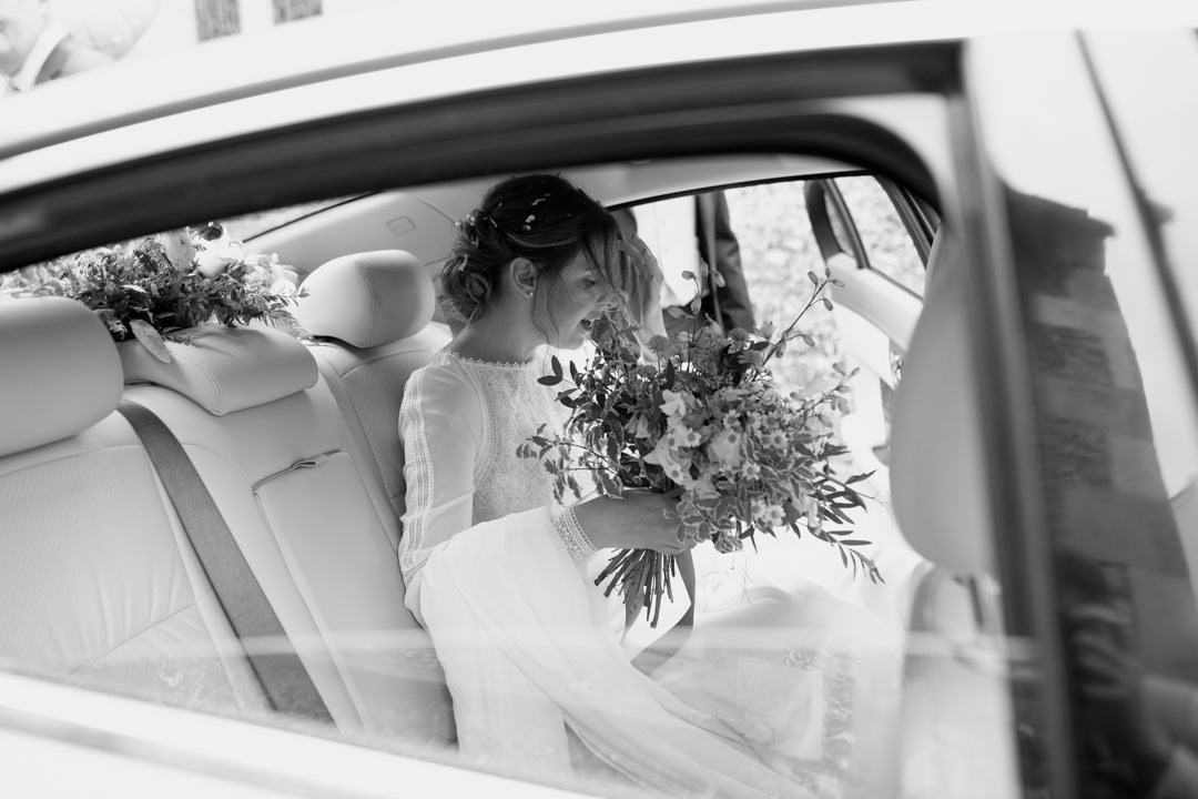 bride in car holding flowers
