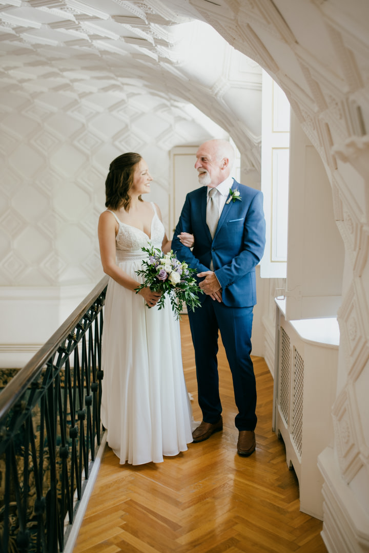 bride and father stood in large room smiling